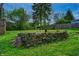Backyard stone fireplace area with barbeque in a fenced yard at 1717 Hst W 10Th St, Anderson, IN 46016