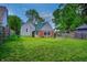 Spacious backyard features lush green lawn and mature trees, providing ample space for outdoor activities at 1717 W 10Th St, Anderson, IN 46016