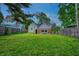 Large, grassy backyard features mature trees and a fenced perimeter, perfect for outdoor entertaining at 1717 W 10Th St, Anderson, IN 46016