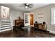 Inviting living room with hardwood floors, classic piano, and a doorway to Mud Room. Stairs lead to upper level at 1717 Hst W 10Th St, Anderson, IN 46016