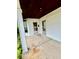 Covered porch with stained wood ceiling featuring a concrete floor and a view of a leafy backyard at 1806 Union St, Columbus, IN 47201