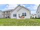 Backyard features a patio with furniture, green lawn, and the rear of the house with blue sky and clouds at 1829 James Pierce Dr, Shelbyville, IN 46176