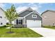 Charming home featuring a two-car garage, well-manicured lawn, and gray wood-look siding at 1829 James Pierce Dr, Shelbyville, IN 46176