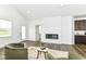 Spacious living room with a modern fireplace, wood floors, and an open layout into the kitchen at 1829 James Pierce Dr, Shelbyville, IN 46176