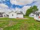 Back of the home showing neutral siding, patio, and yard at 225 S Carthage Rd, Charlottesville, IN 46117