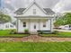 Charming home featuring a covered front porch and well-maintained front yard landscaping at 225 S Carthage Rd, Charlottesville, IN 46117