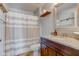 Cozy bathroom features a granite countertop, wood shelf, and shower with striped curtain at 2260 Central Ave, Indianapolis, IN 46205