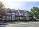Charming townhome featuring a yellow exterior with blue trim, a private balcony, and a well-maintained front yard at 2260 Central Ave, Indianapolis, IN 46205