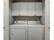White laundry room with washer, dryer, and white cabinets for storage at 2260 Central Ave, Indianapolis, IN 46205