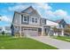Attractive two-story home showcasing a lush green lawn and concrete driveway leading to the garage at 3016 Gibbert Ln, Westfield, IN 46074