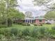 Brick home with charming backyard, featuring a white pergola-covered patio and lush landscaping for serene outdoor living at 31 N Restin Rd, Greenwood, IN 46142