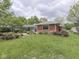 Landscaped backyard featuring a charming brick home with a pergola-covered patio and lush green lawn at 31 N Restin Rd, Greenwood, IN 46142