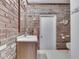 Small bathroom featuring brick accent wall, a toilet, and a wooden vanity with countertop sink at 31 N Restin Rd, Greenwood, IN 46142