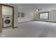 Spacious living room featuring neutral carpet, ceiling fan, and an open laundry room at 31 N Restin Rd, Greenwood, IN 46142