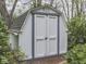 Neat backyard shed featuring double doors, brick pathway, and ample storage space at 31 N Restin Rd, Greenwood, IN 46142