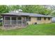 Expansive backyard featuring a screened porch, and lush green lawn surrounded by mature trees at 3412 Loral Dr, Anderson, IN 46013