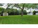 Well-maintained backyard with a lush green lawn, mature trees and storage sheds for added convenience at 3412 Loral Dr, Anderson, IN 46013