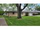 Charming single story home featuring a well-maintained yard with green grass, large tree, and one car garage at 3412 Loral Dr, Anderson, IN 46013