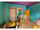 Aqua colored bedroom with several storage totes, hardwood floors, and two doors at 3425 N Elizabeth St, Indianapolis, IN 46226