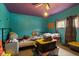 Aqua colored bedroom with hardwood floors and several storage totes at 3425 N Elizabeth St, Indianapolis, IN 46226