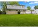 A charming two-story home with stone and siding exterior, complemented by a spacious green front lawn at 3425 N Elizabeth St, Indianapolis, IN 46226
