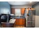Traditional kitchen featuring blue walls, a stainless steel refrigerator, and wood cabinets at 3425 N Elizabeth St, Indianapolis, IN 46226