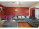 Cozy living room with large gray sectional couch, red accent wall, and a ceiling fan at 3425 N Elizabeth St, Indianapolis, IN 46226