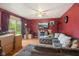 Cozy living room with large gray sectional couch, red accent wall, and a ceiling fan at 3425 N Elizabeth St, Indianapolis, IN 46226