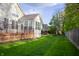A large green backyard and wooden decks on a row of houses on a sunny day at 3438 Windy Knoll Ln, Carmel, IN 46074