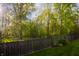 A wood fence encloses the backyard, with lawn, landscaping and mature trees at 3438 Windy Knoll Ln, Carmel, IN 46074