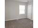 This bedroom features neutral walls and gray carpeting with a window for natural light and a separate closet at 3453 Payton Ave, Indianapolis, IN 46226
