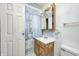 Shot of bathroom with wooden vanity, sink, toilet and floral wall paper at 3514 Eisenhower Dr, Indianapolis, IN 46224