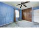 Bedroom features ceiling fan, window, closet, and blue walls at 3514 Eisenhower Dr, Indianapolis, IN 46224