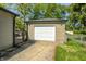View of the detached garage with white door and a driveway in front of the house at 3514 Eisenhower Dr, Indianapolis, IN 46224