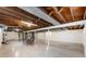 Unfinished basement with exposed wooden beams, concrete floor and painted cinder block walls at 3605 Redfern Dr, Indianapolis, IN 46237