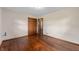Spacious bedroom with hardwood floors, closet, neutral walls, and a view into the hallway at 3605 Redfern Dr, Indianapolis, IN 46237