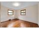 A bedroom with hardwood floors, neutral walls, and two windows at 3605 Redfern Dr, Indianapolis, IN 46237