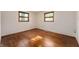An empty bedroom with hardwood floors, two windows, and neutral walls at 3605 Redfern Dr, Indianapolis, IN 46237