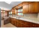 Cozy kitchen with wooden cabinets, tiled countertops, and vintage charm at 3605 Redfern Dr, Indianapolis, IN 46237