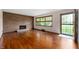 Bright living room featuring hardwood floors, brick fireplace, and large windows at 3605 Redfern Dr, Indianapolis, IN 46237