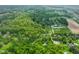 Drone view of property with mature trees and landscaping, including a winding driveway at 3660 S Conservation Club Rd, Morgantown, IN 46160