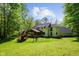 Spacious backyard with play set and lush greenery surrounding a two-story home at 3660 S Conservation Club Rd, Morgantown, IN 46160