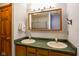 Bathroom with double sinks, wooden cabinets, and wooden trim mirror at 3660 S Conservation Club Rd, Morgantown, IN 46160