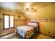 Cozy bedroom with a ceiling fan, charming decor, and shuttered window at 3660 S Conservation Club Rd, Morgantown, IN 46160