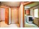 Hallway leading to a laundry room and bathroom, featuring hardwood trim and patterned flooring at 3660 S Conservation Club Rd, Morgantown, IN 46160