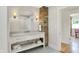 Bathroom boasts patterned tile floors, white vanity, brick accent wall and bright lighting at 3744 S Meridian St, Indianapolis, IN 46217