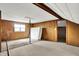 Attic featuring wood-paneled walls, carpet floors, with windows for natural light at 3975 Denwood Dr, Indianapolis, IN 46226