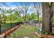 Large backyard features a black fence, many potted plants, and some garden fencing for a pet run at 3975 Denwood Dr, Indianapolis, IN 46226