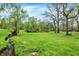 Landscaped backyard has mature trees, and a small creek running along the side of the property at 3975 Denwood Dr, Indianapolis, IN 46226
