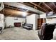 Spacious basement featuring concrete floors, exposed ceilings, and casual seating at 3975 Denwood Dr, Indianapolis, IN 46226